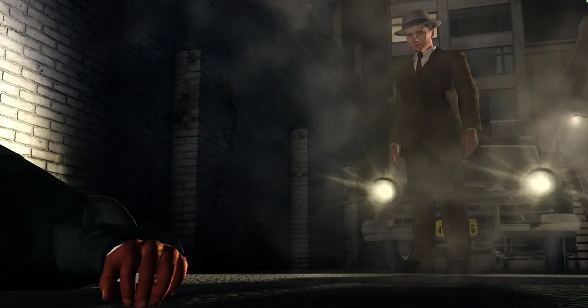 O detetive de L.A. Noire, Cole Phelps, de pé numa rua mal iluminada dos anos 40