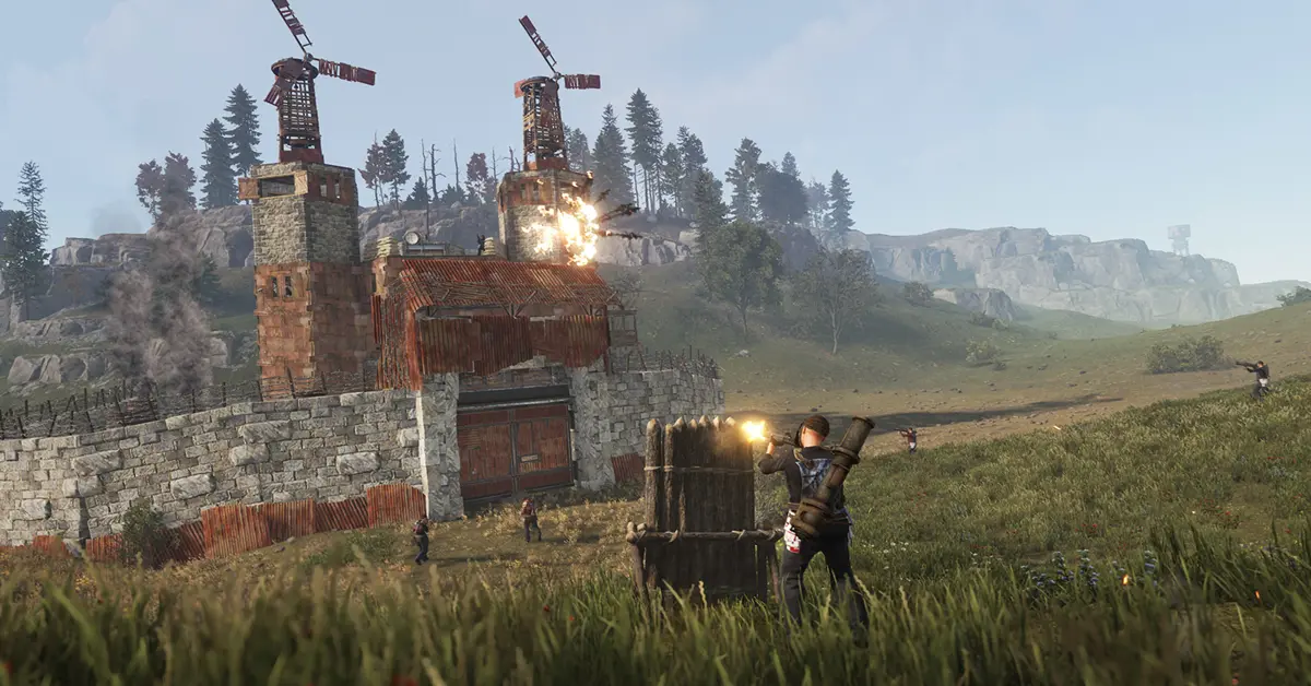 Um jogador está parado do lado de fora de uma base de metal fortificada em Rust, segurando um rifle de assalto fabricado ao amanhecer.